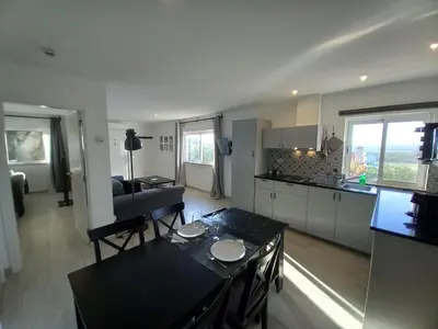 a kitchen and a living room with a table and chairs at Martins Apartment - Belch1952 in Lagos