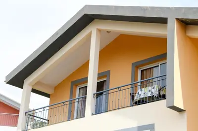a house with a balcony and a dog on the balcony at Casa Simão in Calheta