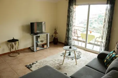 a living room with a couch and a tv at Casa Simão in Calheta