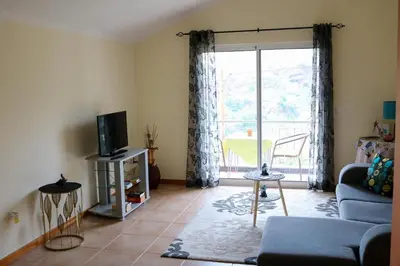 a living room with a couch and a tv at Casa Simão in Calheta