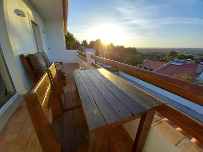 a wooden bench on a balcony with the sunset at Carlos Apartment - Penthouse - Belch1952 in Lagos