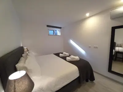 a hotel room with a bed and a mirror at Lopes Apartment - Belch1952 in Lagos