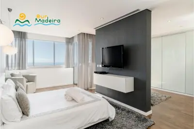 a living room with a tv on a wall at OurMadeira - Fonte do Mar 1 in Caniço