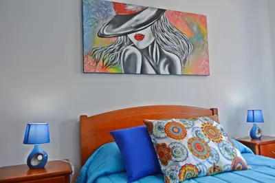 a bedroom with a bed with a painting on the wall at Apartment in Câmara de Lobos in Câmara de Lobos