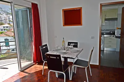 a dining room with a table and chairs and a balcony at Apartment in Câmara de Lobos in Câmara de Lobos