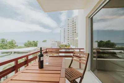 a bottle of wine sitting on a wooden table on a balcony at Alto Lido by Madeira Best Apartments in Funchal