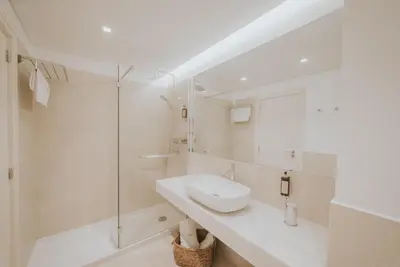 a white bathroom with a sink and a shower at Alto Lido by Madeira Best Apartments in Funchal