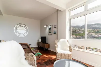 a living room with a table and chairs and a window at Quinta Deão I by An Island Apart in Funchal