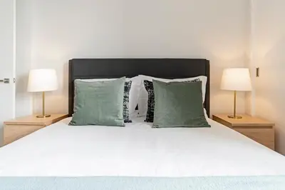 a bedroom with a bed with green pillows and two lamps at Quinta Deão I by An Island Apart in Funchal