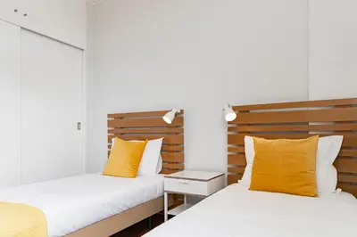 two beds in a room with yellow pillows at Quinta Deão I by An Island Apart in Funchal