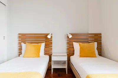 two beds in a room with yellow pillows at Quinta Deão I by An Island Apart in Funchal