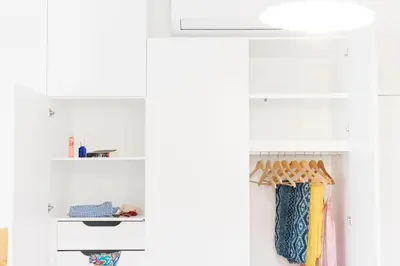 a closet with white walls and white shelves at Apartamentos Praça Amarela by Heart of Funchal in Funchal