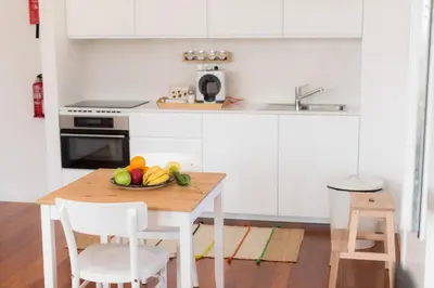 a kitchen with a table with a bowl of fruit on it at Apartamentos Praça Amarela by Heart of Funchal in Funchal