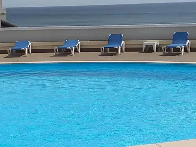 a row of blue chairs next to a swimming pool at Apartamento Maria in Lagos