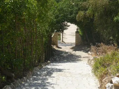 a path with an archway with trees and a building at Apartamento Maria in Lagos