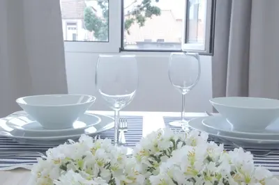 a table with two wine glasses and white flowers at Ribeira Funchal Center in Funchal