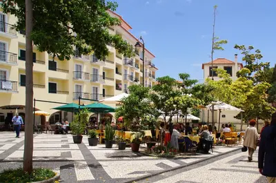 a group of people sitting at tables outside a building at Ribeira Funchal Center in Funchal
