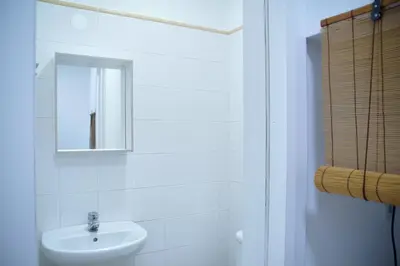 a white bathroom with a sink and a mirror at Ribeira Funchal Center in Funchal