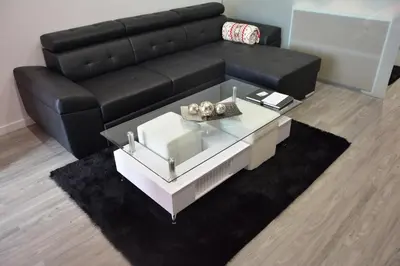 a living room with a black couch and a coffee table at Sea and Sun 4 You - Choupana Studio in Funchal