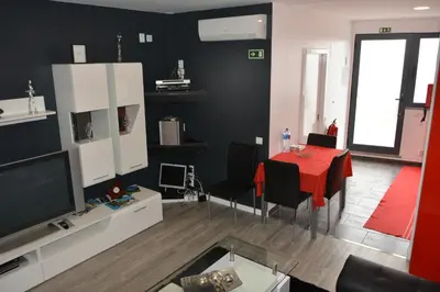 a living room with a red table and a television at Sea and Sun 4 You - Choupana Studio in Funchal