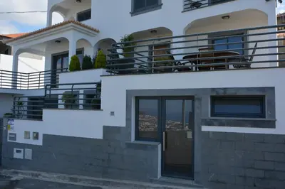 a white house with a balcony on the side at Sea and Sun 4 You - Choupana Studio in Funchal