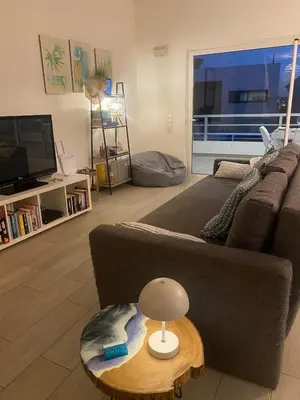 a living room with a couch and a table with a lamp at DuMar Beachouse in Salema