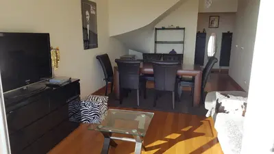a living room with a table and a dining room at PERFECT DUPLEX PISCINE Zone VIP Funchal in Funchal