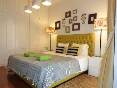 a bedroom with a bed with green pillows on it at Casa Marias in Calheta