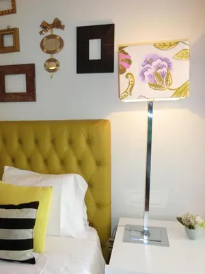 a bed with a yellow headboard and a table with a lamp at Casa Marias in Calheta