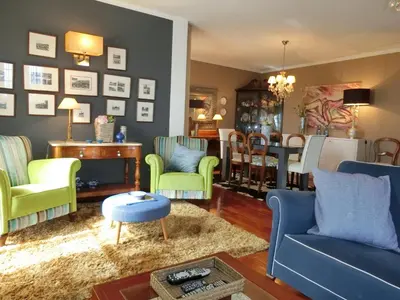 a living room with blue and green chairs and a table at Casa Marias in Calheta