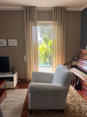 a living room with a white couch and a piano at Casa Marias in Calheta