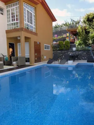 a large blue swimming pool in front of a building at Casa Marias in Calheta