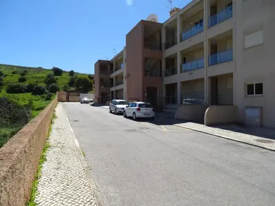 a street with cars parked next to a building at Casa Afonso Henriques in Burgau