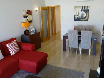 a living room with a red couch and a table at Casa Afonso Henriques in Burgau