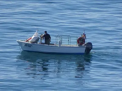 two men on a boat in the water at Casa Afonso Henriques in Burgau