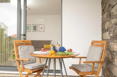a dining room with a table and chairs at BHF Residences Lotus in Calheta