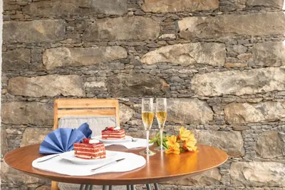 a table with two glasses of champagne and cakes at BHF Residences Lotus in Calheta