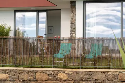 a fence in front of a house with windows at BHF Residences Lotus in Calheta