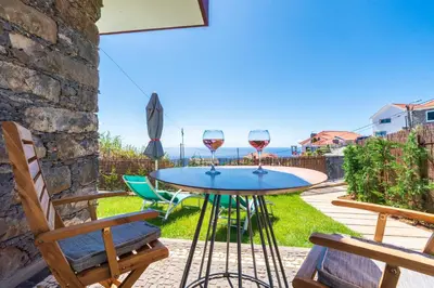 a table with two glasses of wine on a patio at BHF Residences Lotus in Calheta