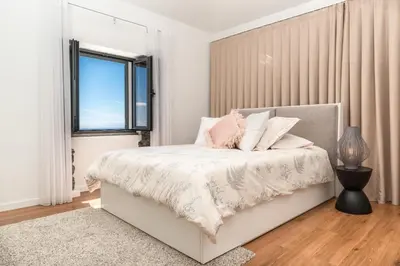 a white bedroom with a bed and a window at BHF Residences Ying Yang in Calheta