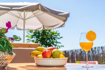 a bowl of fruit on a table with a glass of wine at BHF Residences Ying Yang in Calheta
