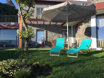 two chairs and an umbrella on a lawn at BHF Residences Ying Yang in Calheta
