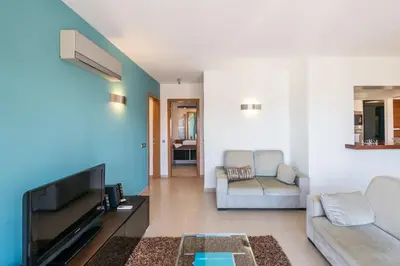 a living room with a couch and a tv at Mar da Luz Terrace Apt 118 in Lagos