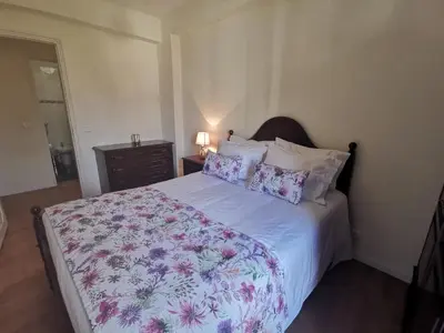 a bedroom with a bed with a floral bedspread and pillows at Apartment in the city of Funchal up 2 at 6 pers in Gaula