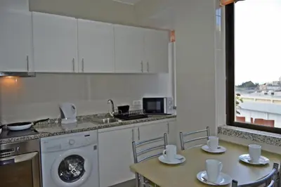 a kitchen with a washing machine and a table with chairs at Apartment in the city of Funchal up 2 at 6 pers in Gaula