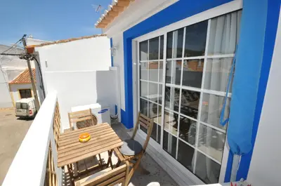 a balcony with a wooden table and a chair at Casa Azul in Barão de São João