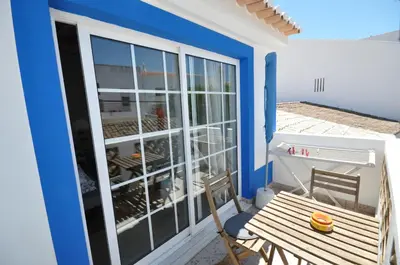 a small balcony with a table and a bench at Casa Azul in Barão de São João