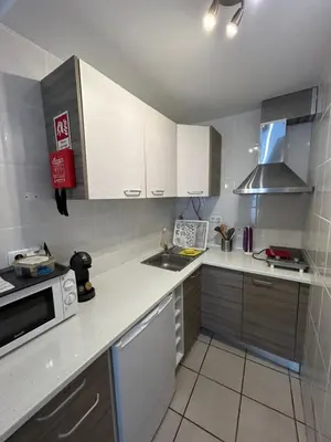 a kitchen with white cabinets and a sink and a microwave at Casa Azul in Barão de São João