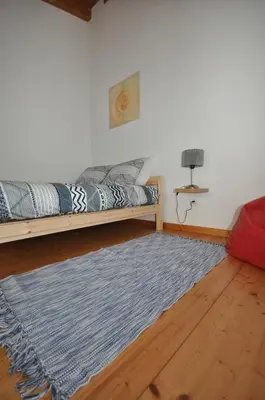 a living room with a bed and a blue rug at Casa Azul in Barão de São João