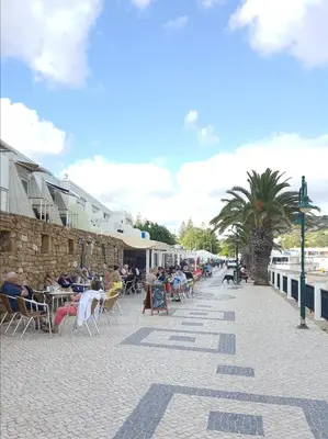 a group of people sitting at tables on a sidewalk at Casa Luztour in Luz